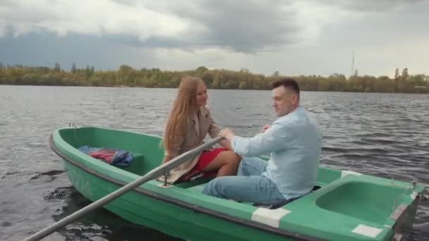 En man och hans leende älskling under en romantisk båttur på floden. Familj och lycka koncept. Långsamma rörelser — Stockvideo