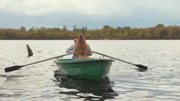 一对恋人爱上了一个男人和一个年轻的女孩在夏天的一天在湖上划船。慢动作 — 图库视频影像