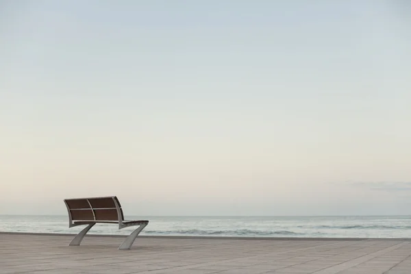 Die einsame Bank am Meer Stockbild