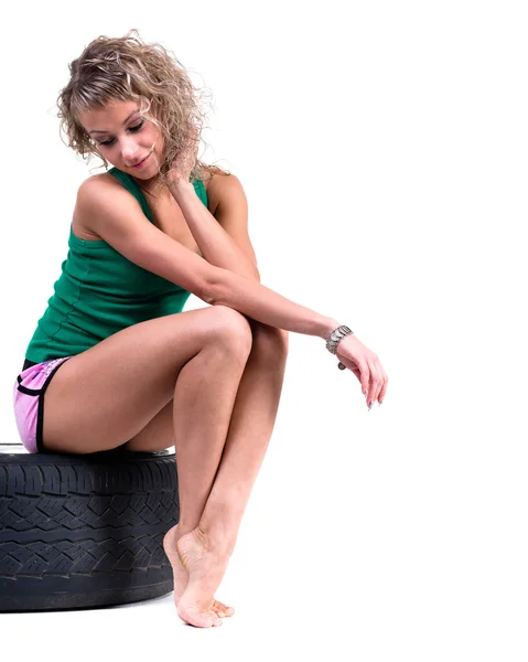 Young sexy girl sitting on the car wheels — Stock Photo, Image