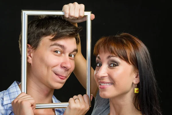 젊은 커플 재미 프레임을 통해 얼굴을 만들기 — 스톡 사진