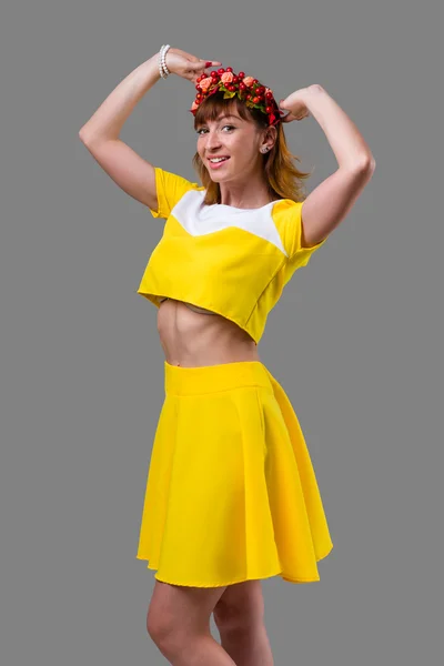 Femme en robe jaune avec couronne rouge isolée sur gris — Photo