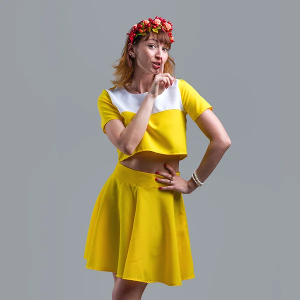 Woman in yellow dress with red wreath isolated on gray — Stock Photo, Image