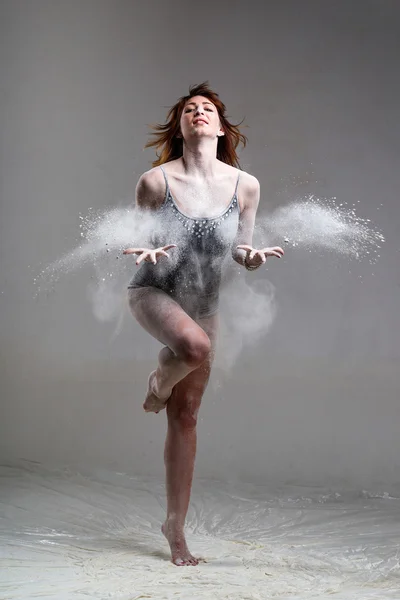 Beautiful expressive ballet dancer posing with flour at studio — Stock Photo, Image