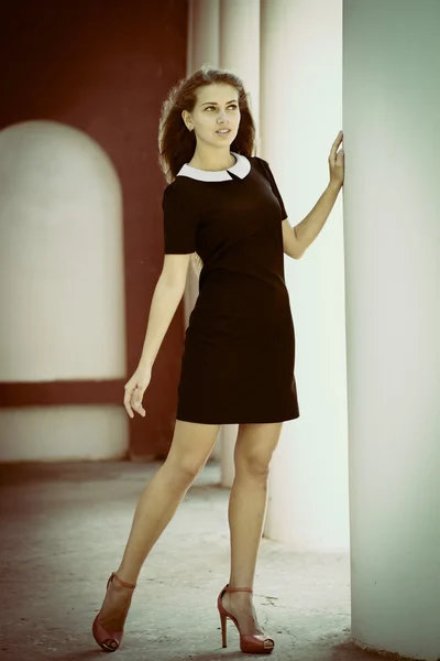 Young woman posing near white columns outdoors — Stock Photo, Image