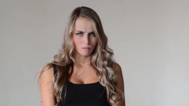 Hayal kırıklığı. Kızgın ve stresli genç kadın gri arka plan üzerinde.