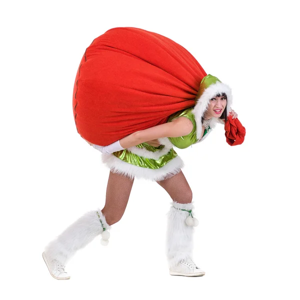 Woman dressed like a funny gnome pulls red bag with gifts, isolated on white — Stock Photo, Image