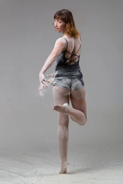 Beautiful expressive ballet dancer posing with flour at studio — Stock Photo, Image