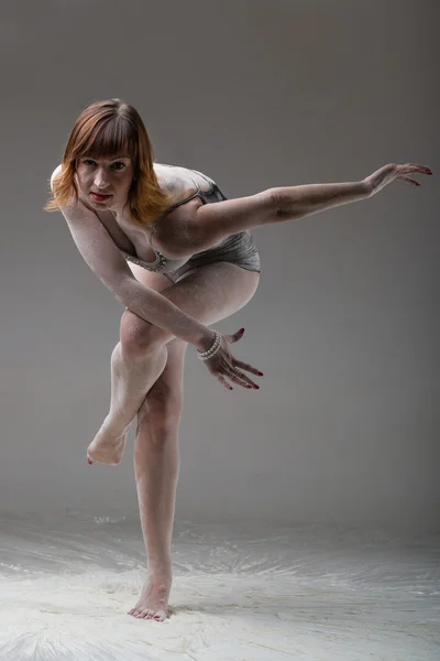 Beautiful expressive ballet dancer posing with flour at studio — Stock Photo, Image