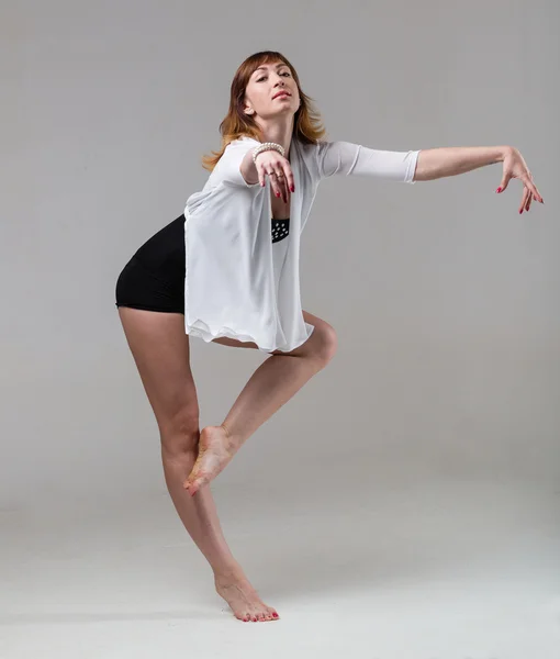 Young woman ballerina ballet dancer dancing on gray background — Stock Photo, Image