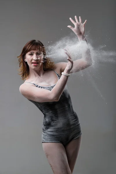 Beautiful expressive ballet dancer posing with flour at studio — Stock Photo, Image