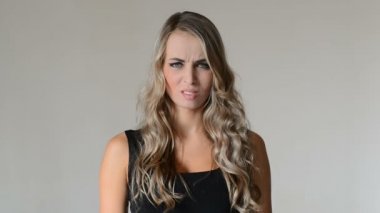 Hayal kırıklığı. Kızgın ve stresli genç kadın gri arka plan üzerinde.