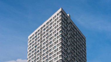 Modern bir binanın köşesi mavi gökyüzüne karşı, arka plan.