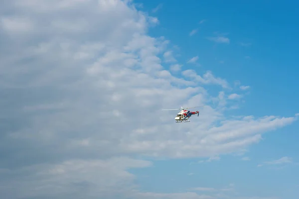 O helicóptero está voando no céu com nuvens. — Fotografia de Stock