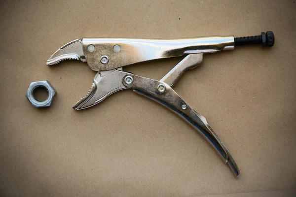 Close up locking pliers on wooden background, Hand tools in work shop. — Stock Photo, Image