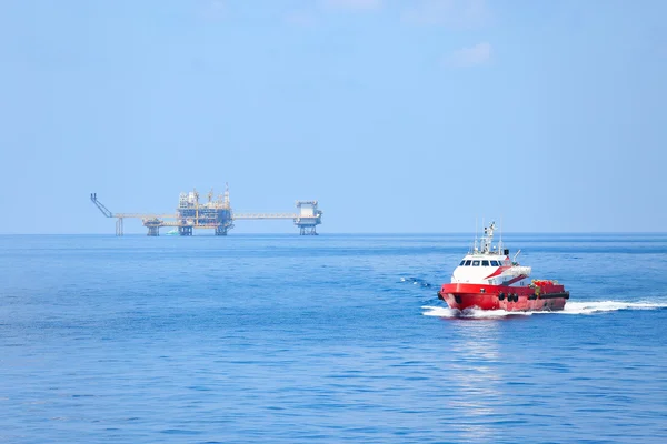 Supply boat transfer cargo to oil and gas industry and moving cargo from the boat to the platform, boat waiting transfer cargo and crews between oil and gas platform with the boat — Stock Photo, Image
