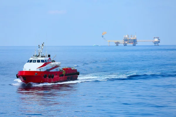 Supply boat transfer cargo to oil and gas industry and moving cargo from the boat to the platform, boat waiting transfer cargo and crews between oil and gas platform with the boat — Stock Photo, Image