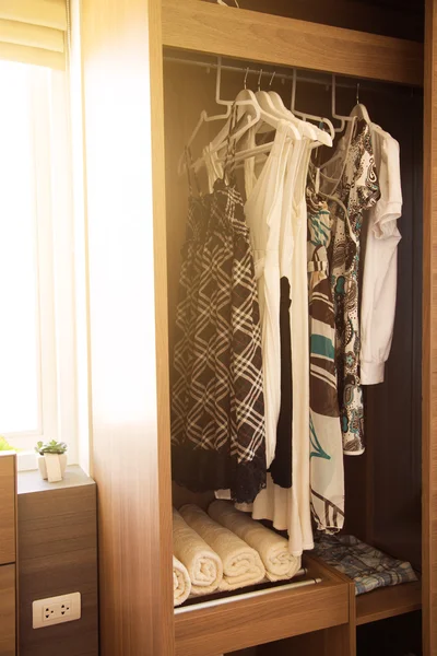 Clothes hang on a shelf in a designer clothes store, Modern closet with row of clothes hanging in wardrobe, Vintage rooms and personal belongings kept in the room which feeling luxury and relax.