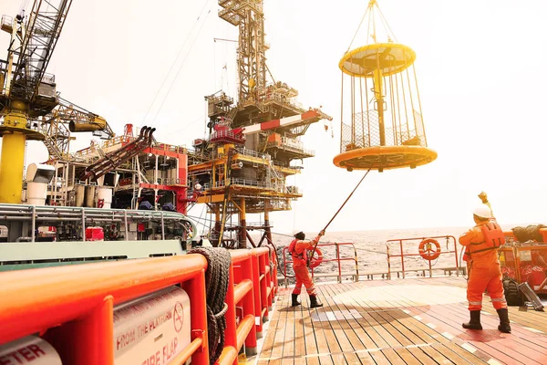 乗客と貨物をプラットフォームから石油 ガス産業の供給船に移動させる乗組員のボート ボートやサービスチームによるオフショア石油 ガス業界のサポート ロイヤリティフリーのストック画像