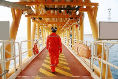 Offshore oil and gas industry and operated by technician petroleum. Worker walking to oil and gas plant for work as routine plan. Maintenance and Operation work scope in oil and gas plant. clipart