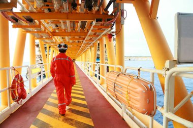 Offshore oil and gas industry and operated by technician petroleum. Worker walking to oil and gas plant for work as routine plan. Maintenance and Operation work scope in oil and gas plant. clipart