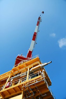 Körfezde ya da açıkta duran petrol ve gaz platformu teknisyenler tarafından işletiliyor. Crane, malzeme sepetinden platforma yük sepetini taşıyor. Ağır yük vinç teknisyeni tarafından taşınıyordu..