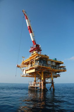 Körfezde ya da açıkta duran petrol ve gaz platformu teknisyenler tarafından işletiliyor. Crane, malzeme sepetinden platforma yük sepetini taşıyor. Ağır yük vinç teknisyeni tarafından taşınıyordu..