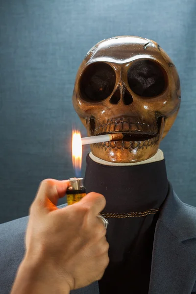 Menschlicher Schädel, der eine Zigarette auf schwarzem Hintergrund raucht, Zigarette sehr gefährlich für Menschen. Bitte nicht rauchen.halloween day. — Stockfoto
