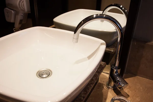 Waterdruppel uit de kraan, zoet water in badkamer. — Stockfoto