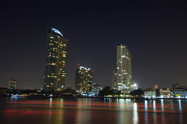Rascacielos por la noche cerca del agua, El edificio cerca del río —  Fotos de Stock
