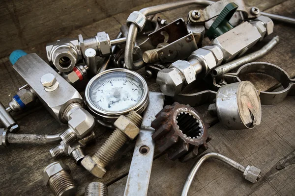 Old machine parts in machinery shop on wooden background. — Stock Photo, Image