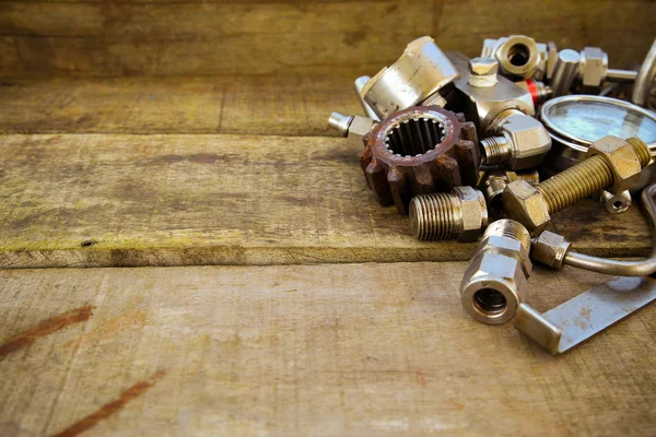 Old machine parts in machinery shop on wooden background. — Stock Photo, Image