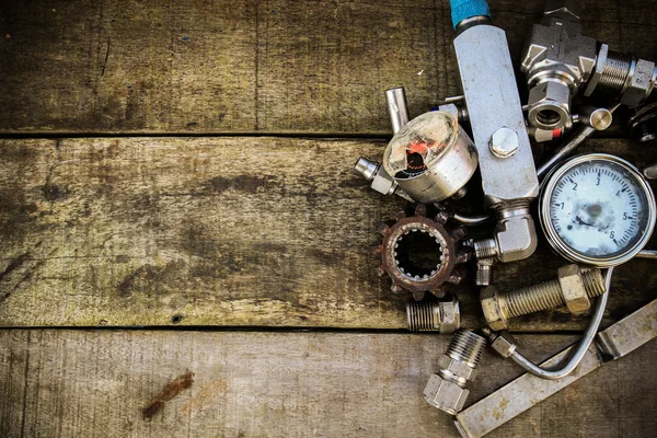 Old machine parts in machinery shop on wooden background. — Stock Photo, Image