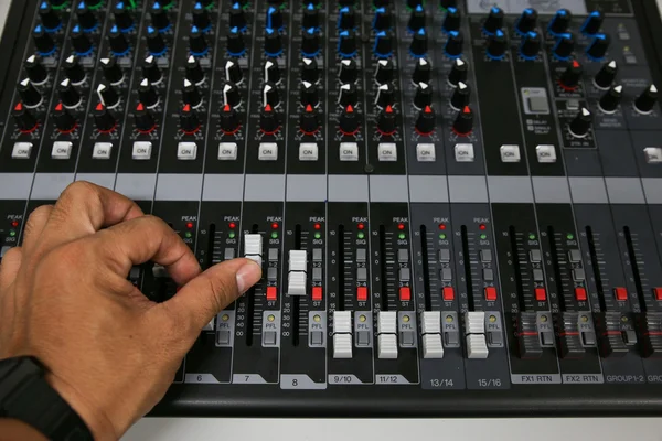 Mão em uma mesa de mistura Fader na galeria de televisão, equipamentos de música na sala de treinamento . — Fotografia de Stock