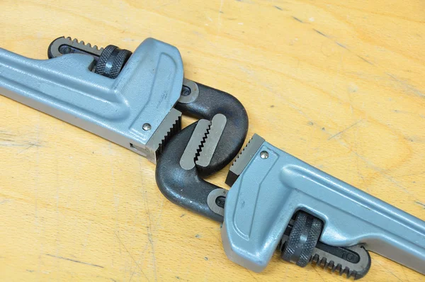 Serie di utensili manuali su uno sfondo di legno, chiave inglese o chiave a tubo per un duro lavoro . — Foto Stock