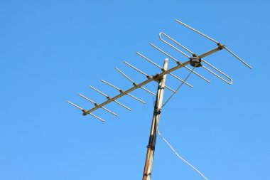 Mavi gökyüzü ile evin çatısında eski Tv anteni