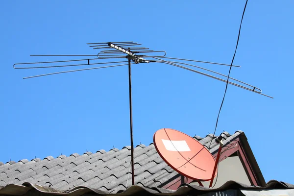 青い空と家の屋根の上の古いテレビ アンテナ — ストック写真