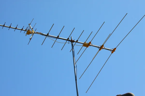 青い空と家の屋根の上の古いテレビ アンテナ — ストック写真