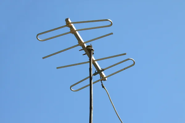 青い空と家の屋根の上の古いテレビ アンテナ — ストック写真