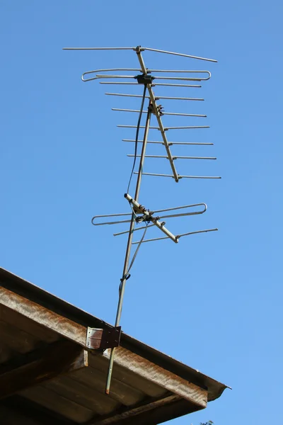 Antena de TV velha no telhado da casa com céu bule — Fotografia de Stock