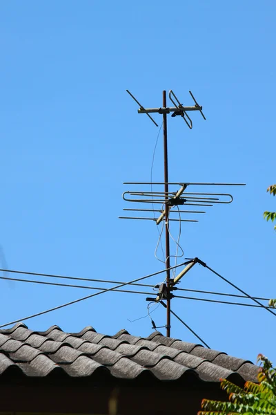 Antigua antena de TV en el techo de la casa con el cielo bullicio —  Fotos de Stock