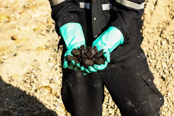 Sviluppo di sabbie petrolifere da un distretto di perforazione petrolifera. La mano sulle sabbie bituminose. Operatore prendere olio sabbia s campione dalla miniera . — Foto Stock