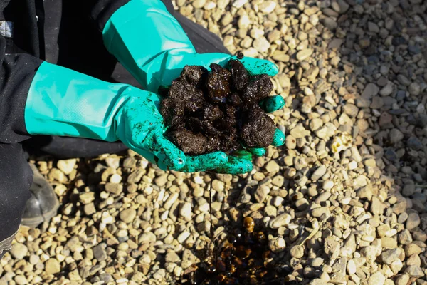 Oil sands development from an oil drilling district. The hand on the oil sands. Operator take oil sand s sample from mine. — Stock Photo, Image