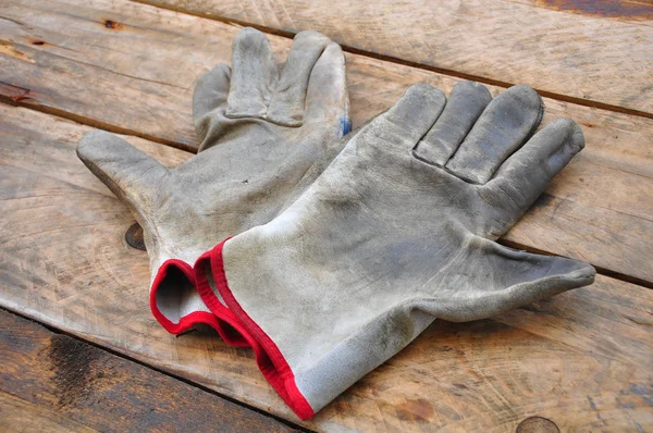 Stary rękawice ochronne na drewniane tła, rękawice na brudnej roboty. — Zdjęcie stockowe