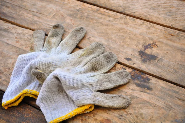 老安全手套在木制的背景下，手套上肮脏的作品. — 图库照片