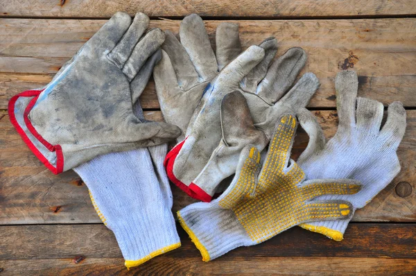 Old safety gloves on wooden background, Gloves on dirty works. — Stock Photo, Image