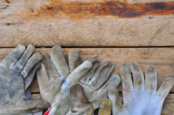Vieux gants de sécurité sur fond en bois, Gants sur travaux sales . — Photo