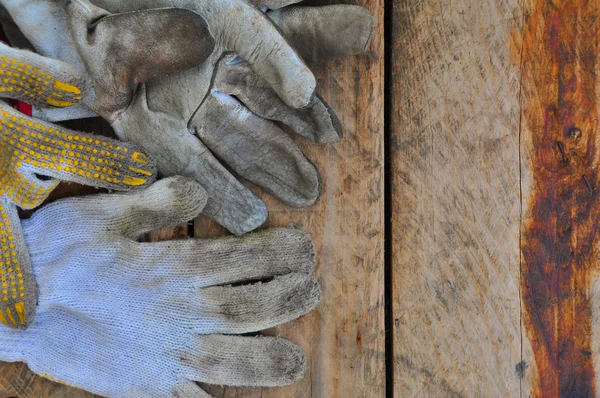 Eski Emanet eldiven eldiven kirli işleri üzerinde ahşap arka plan üzerinde. — Stok fotoğraf