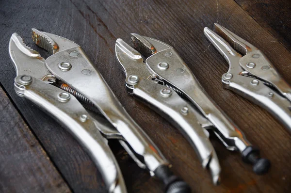 Close up locking pliers on wooden background, Hand tools in work shop. — Stock Photo, Image