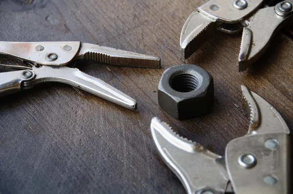 Close up locking pliers on wooden background, Hand tools in work shop. — Stock Photo, Image